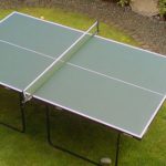 Familia jugando ping pong en el jardín